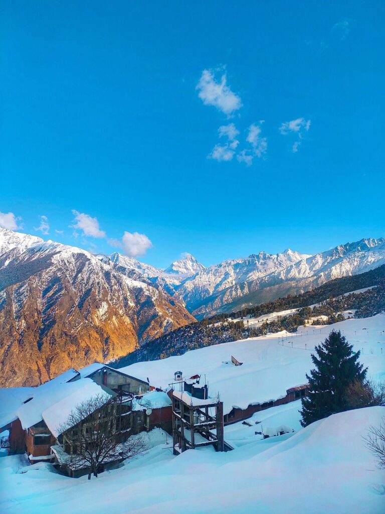 Snow-covered slopes of Auli with chair lifts and panoramic Himalayan views