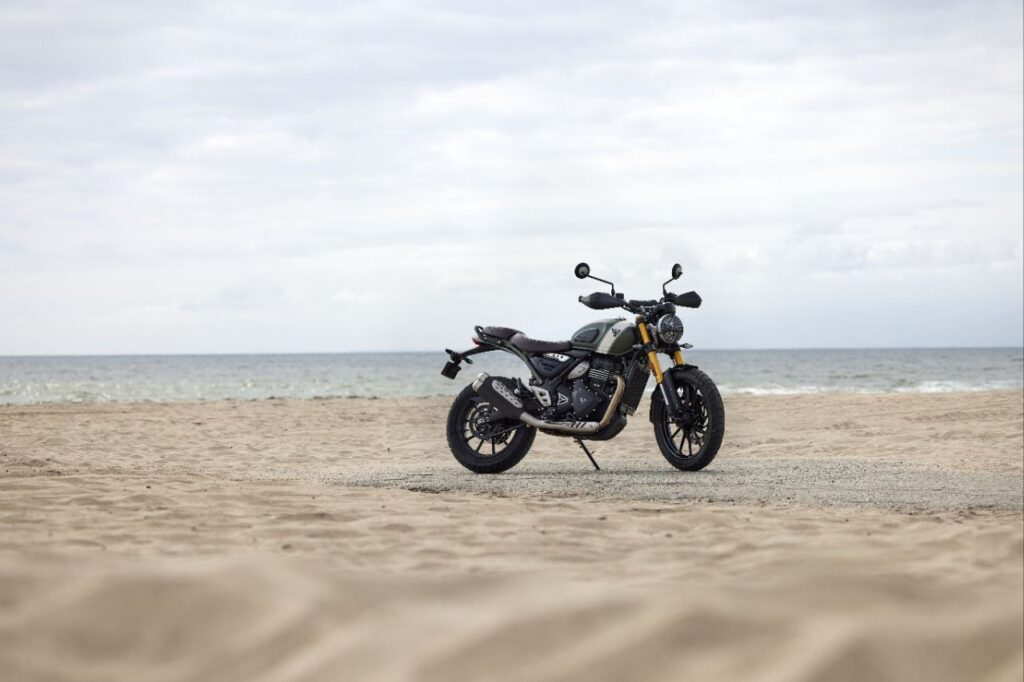 Side view of Triumph Scrambler 400 XC parked on dirt road